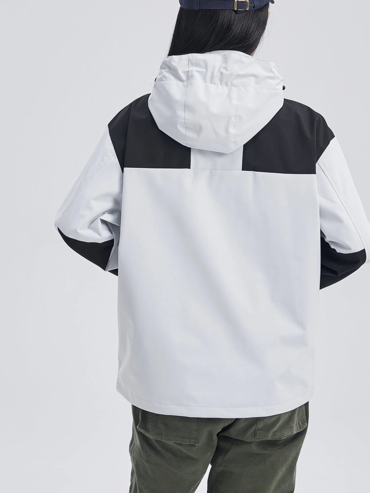 Model wearing the light grey hooded jacket from behind, showing the fit, hood and black colour-block detailing