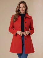 Red wool coat worn open at the front over a black jumper, showing the classic collar and dark button detailing