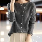Dark grey cardigan styled with a cream pleated skirt, showing the full button row and hem