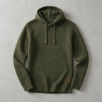 Army green textured knit hoodie laid flat with ribbed cuffs and hem and a small leather brand patch