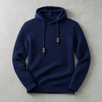 Navy blue knit hoodie laid flat with tan toggle details and ribbed cuffs and waistband