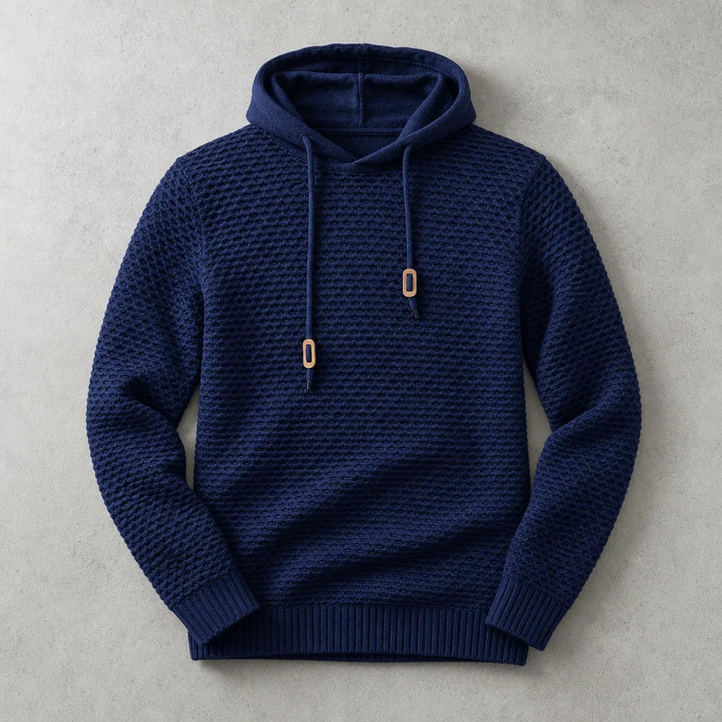 Navy blue knit hoodie laid flat with tan toggle details and ribbed cuffs and waistband