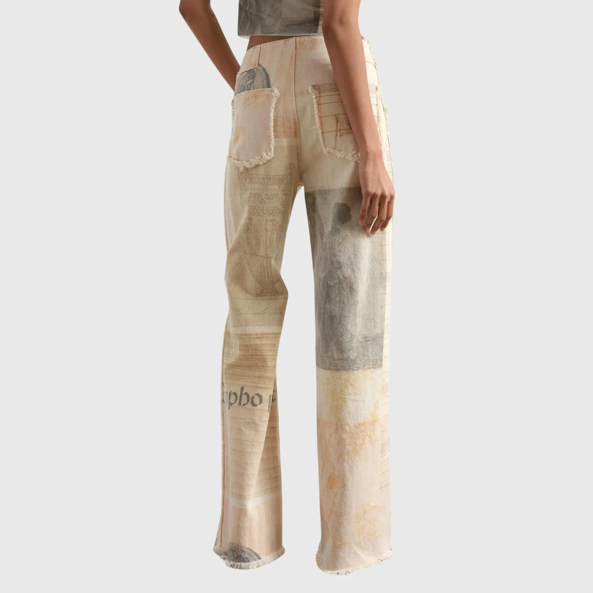 Back view showing high waist, frayed patch pockets and archival-style print across wide-leg trousers