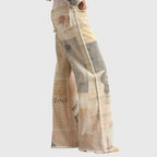 Side profile highlighting the wide flared leg and raw frayed side seam of the printed jeans