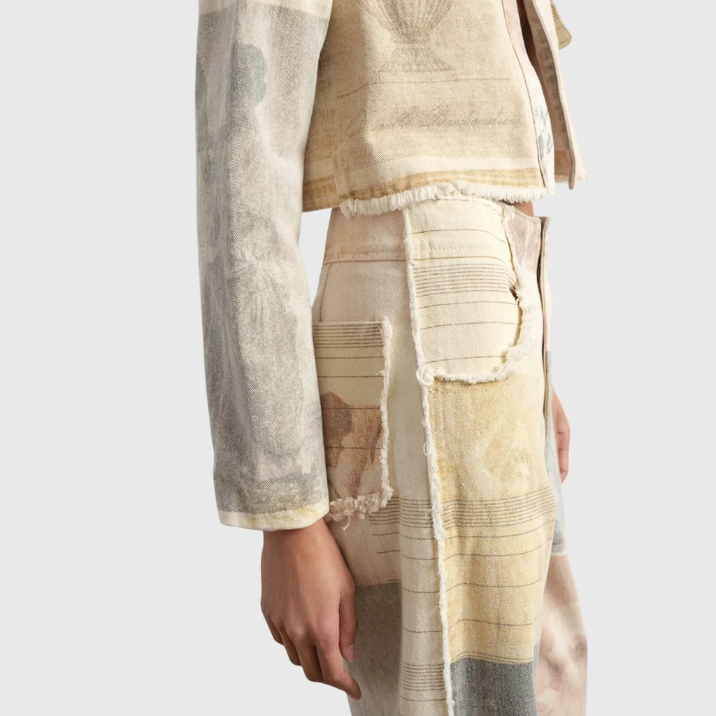 Close-up of cropped jacket and trouser waistband showing frayed pocket edges and mixed panel prints