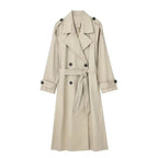 Beige double-breasted trench coat with wide lapel collar and tied waist belt, front view on model