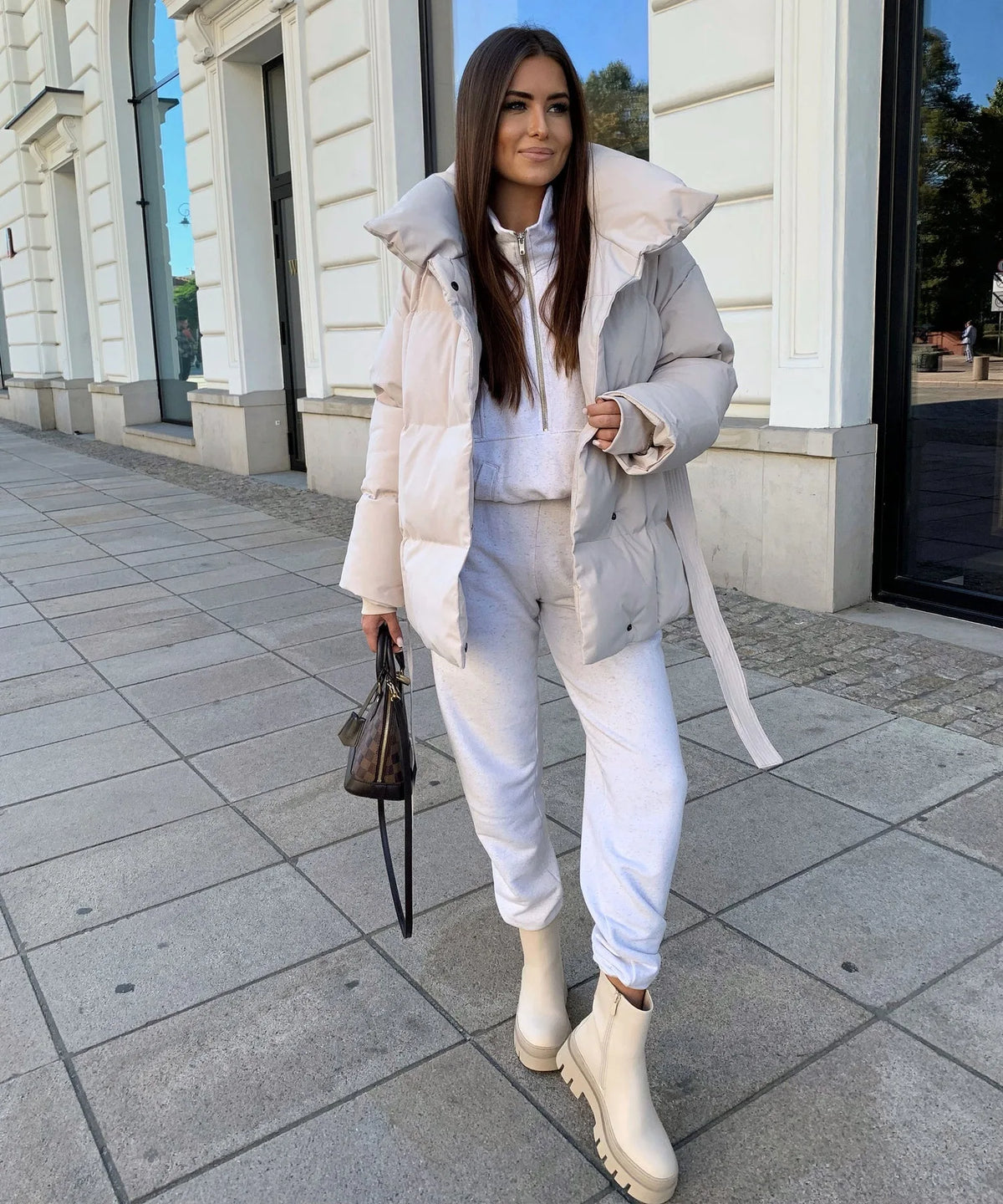 Cream puffer jacket worn with matching grey loungewear and cream chunky boots, walking outdoors