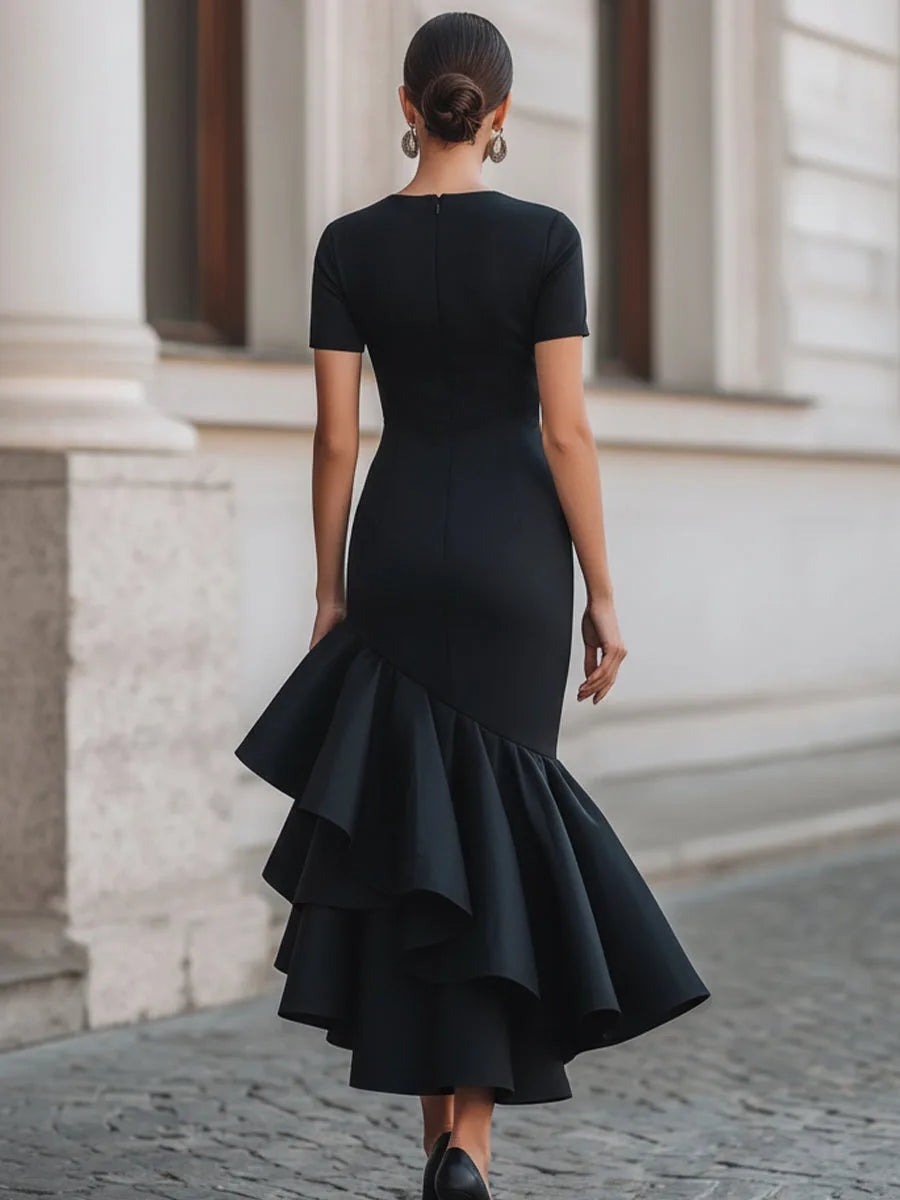 Back view of the black midi dress showing the fitted zip bodice and tiered ruffle hem falling to the calf