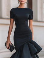 Close-up of the high neckline, short fitted sleeves and smooth structured fabric across the shoulders and bust