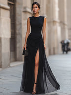 Front view of the black draped gown showing the high neckline, fitted waist and flowing chiffon overlay.