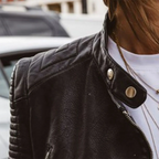 Detail shot of the collar with snap button closure and quilted diamond-stitched shoulder panel in black faux leather
