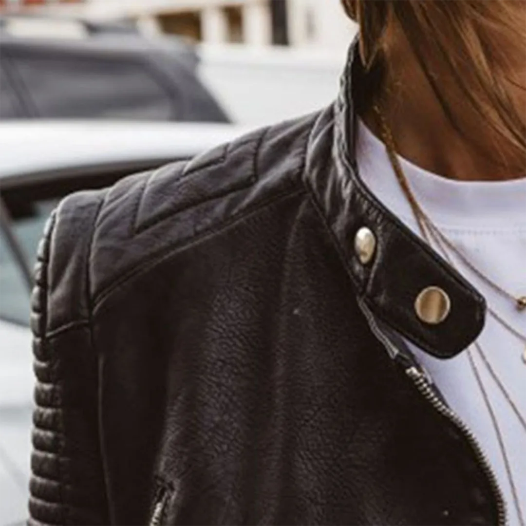 Detail shot of the collar with snap button closure and quilted diamond-stitched shoulder panel in black faux leather