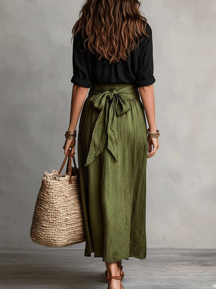 Back view showing the olive green skirt's tie-waist bow detail and relaxed A-line shape