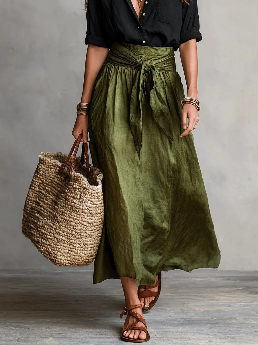 Close-up of the olive green skirt's wrap-tie waistband and flowing midi-length fabric