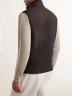 Rear view showing the plain back and high collar of the brown brushed-wool gilet with ribbed knit sleeves