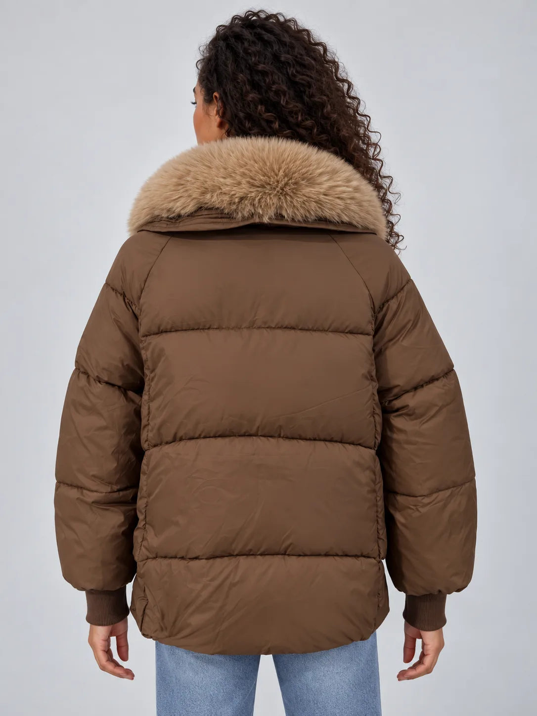 Back view showing the quilted panelling, ribbed cuffs and voluminous fur-trimmed collar of the brown puffer jacket