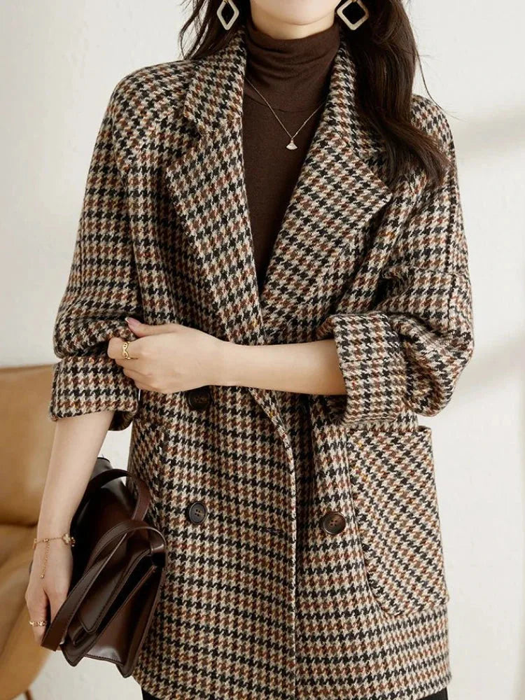 Close-up of the brown houndstooth blazer showing double-breasted button fastening and patch pockets