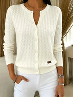 Cream white cable knit cardigan with buttons, close-up of ribbed neckline and vertical cable pattern