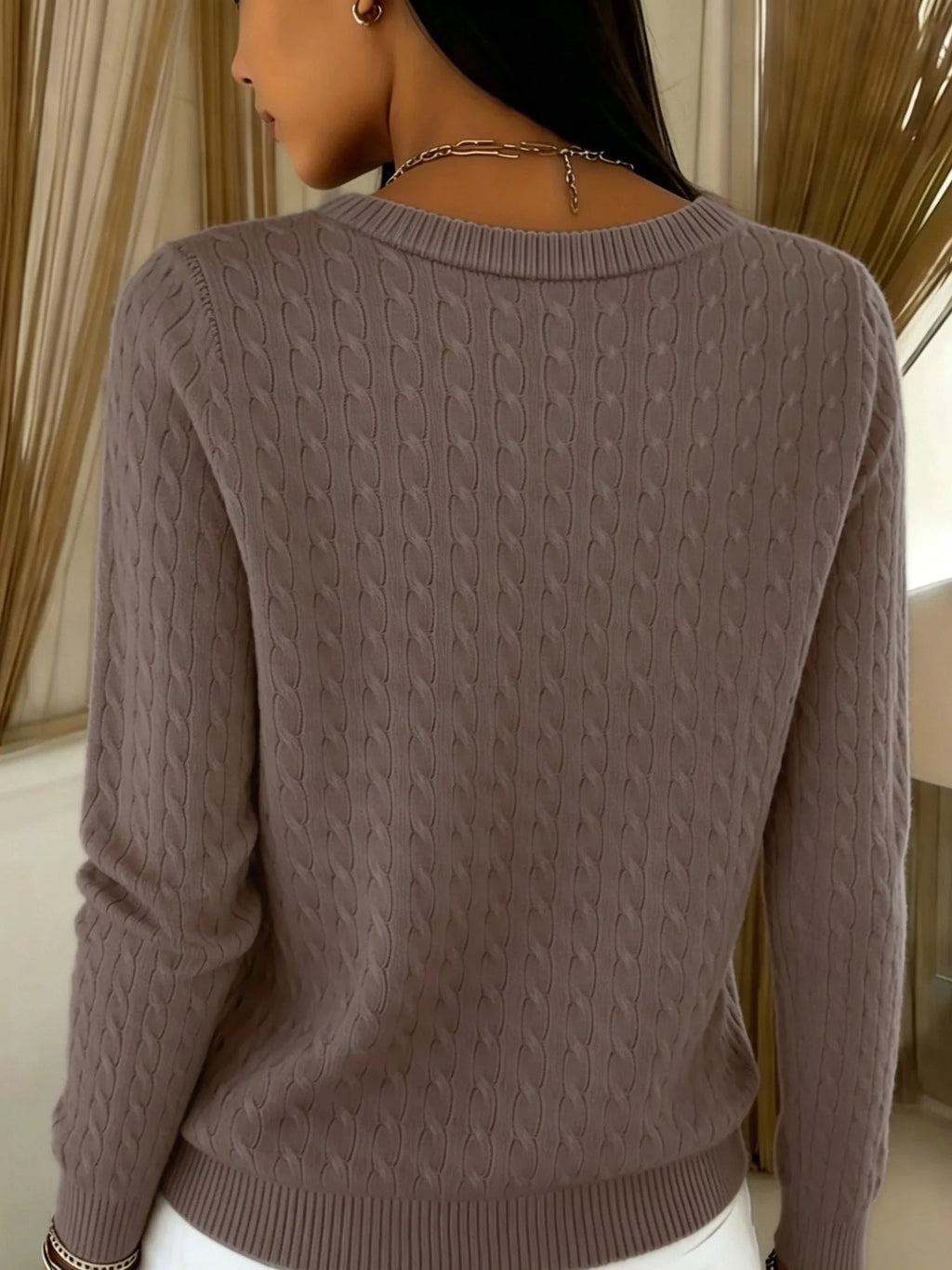 Back view of coffee brown cable knit cardigan showing ribbed collar and cable-knit texture across shoulders