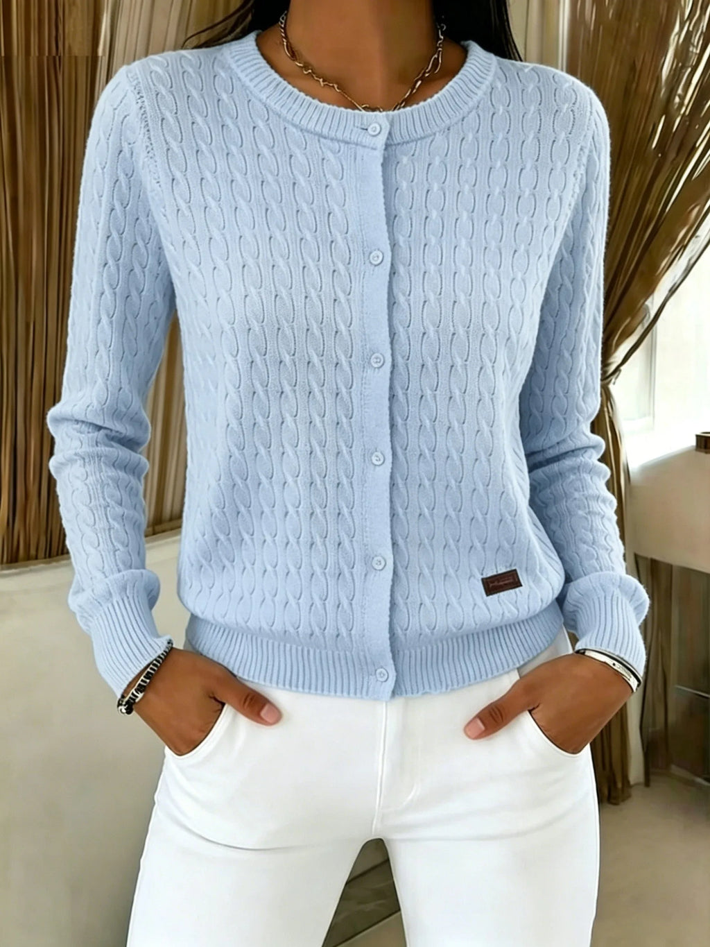 Light blue cable knit cardigan fully buttoned, front view showing ribbed cuffs and hem