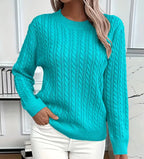 Bright turquoise cable-knit jumper with ribbed trim at the neckline, close-up front view