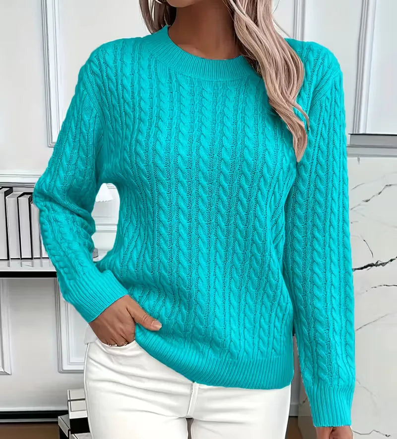 Bright turquoise cable-knit jumper with ribbed trim at the neckline, close-up front view
