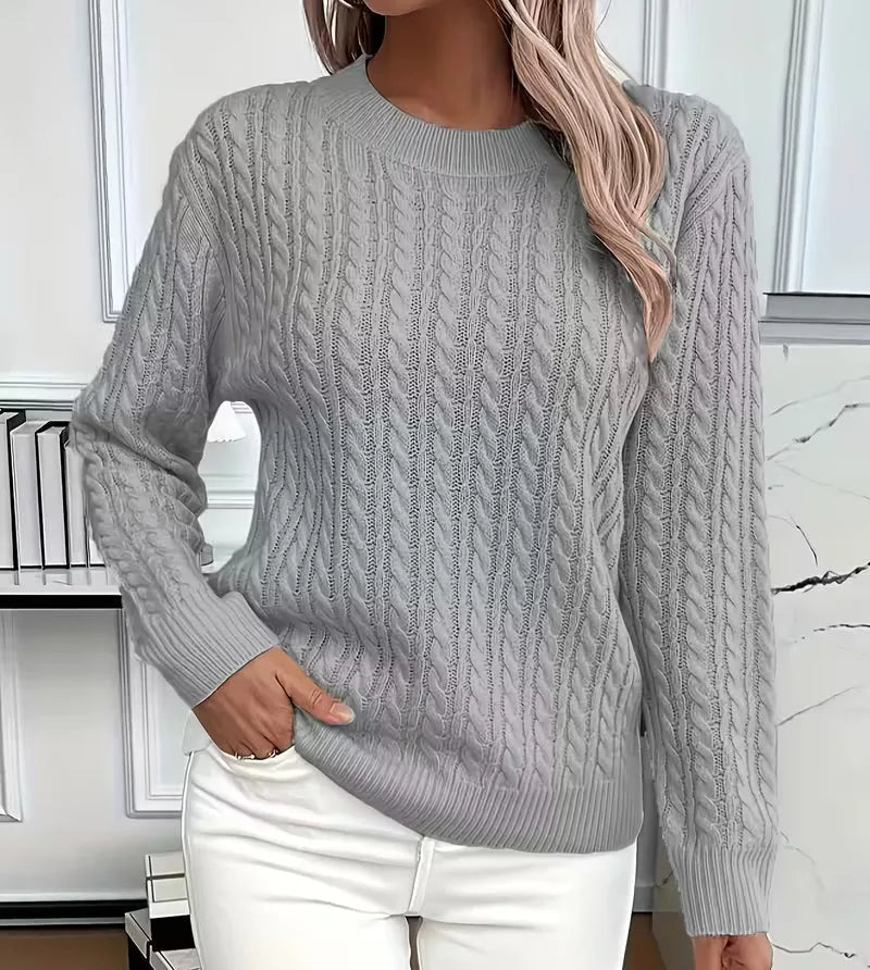 Light grey cable-knit jumper with ribbed hem, paired with white trousers