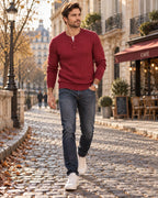 Burgundy red cable-knit Henley jumper with three-button placket, worn with slim dark denim and white trainers.