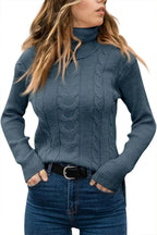 Blue cable-knit polo neck jumper, front view with hands resting in jean pockets