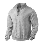 Close-up front view of beige cable-knit jumper showing zip pull, ribbed cuffs and hem detail