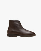 Side profile of a dark brown pebbled leather ankle boot with front zip and lugged rubber sole