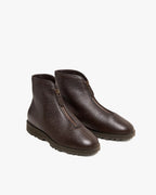 Angled front view of a pair of brown textured leather zip-front boots showing gold-tone zip pulls