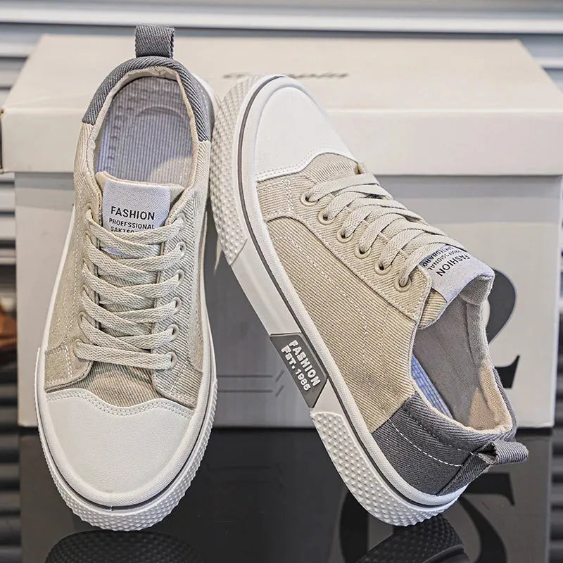 Beige and grey canvas trainers with white sole, one shoe standing and one tipped on its side