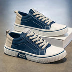 Side profile of blue canvas trainers showing the white rubber sole and FASHION heel logo