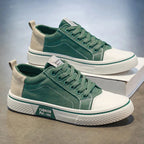 Side profile of green canvas trainers highlighting the beige heel panel and ribbed outsole