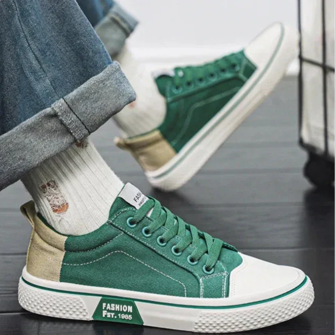 Close-up of a person wearing a green canvas trainer with rolled-up jeans and ribbed socks