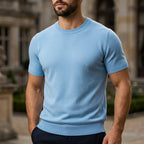Light blue short-sleeve knitted T-shirt with ribbed collar and cuffs, worn with navy trousers outdoors