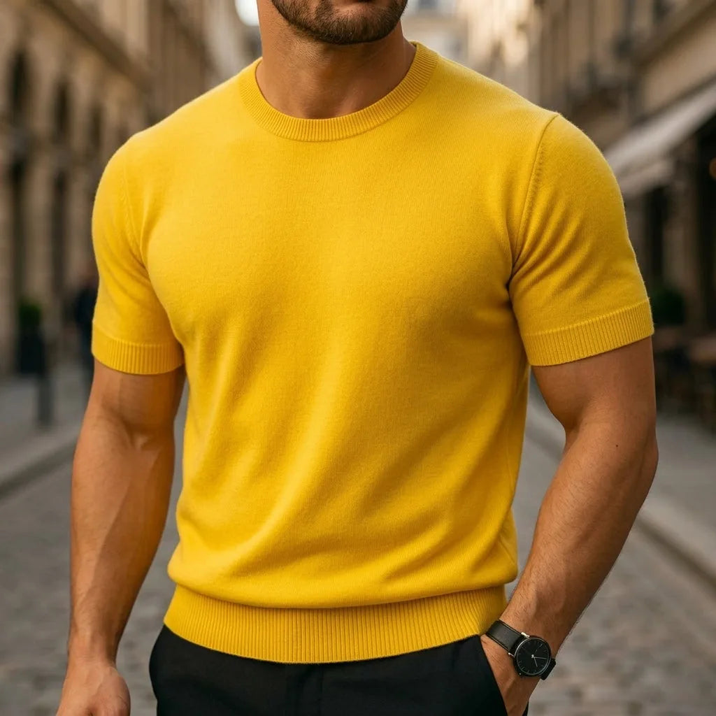 Mustard yellow short-sleeve knitted T-shirt with ribbed collar, paired with black trousers and a wristwatch