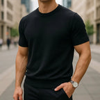 Black short-sleeve knitted T-shirt with ribbed crew neck, paired with navy trousers and a wristwatch
