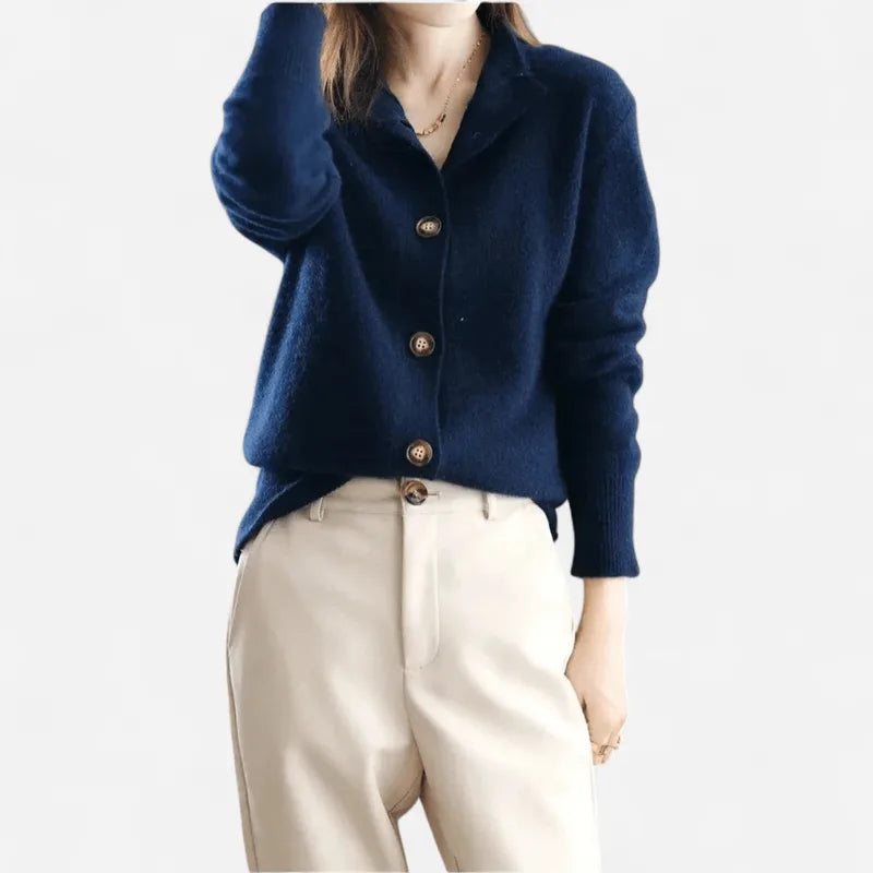 Navy blue cashmere cardigan with notched lapel collar and wooden buttons, paired with cream trousers