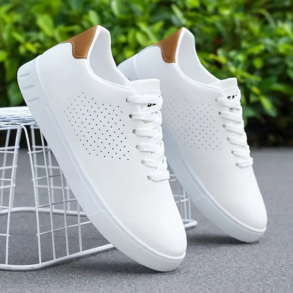 Side view of white lace-up trainers with tan heel trim resting on a white wire stool amid greenery