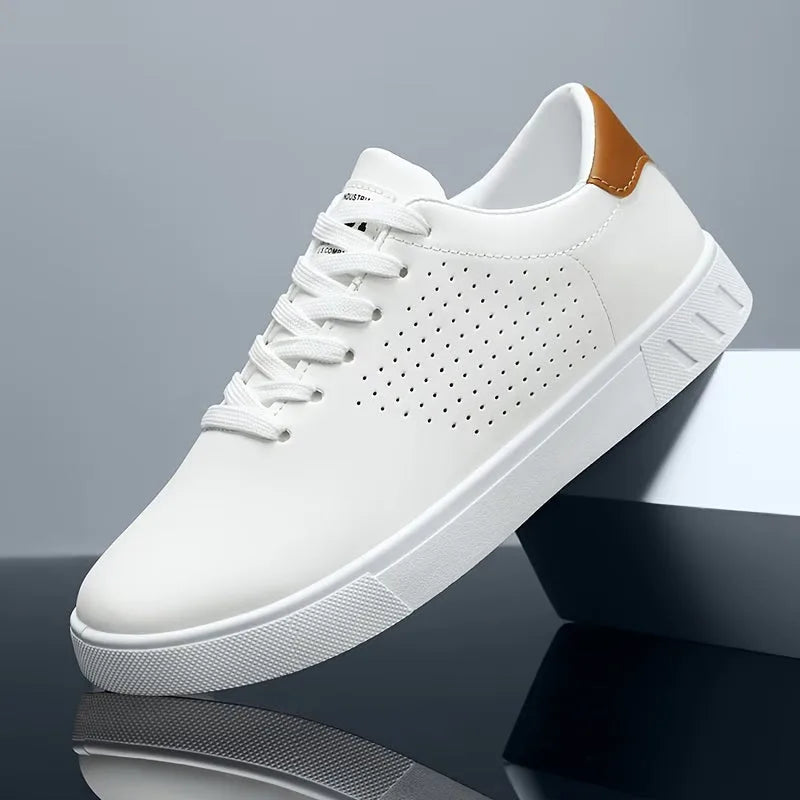 Single white trainer with tan heel patch and perforated toe shown balanced on a glossy block