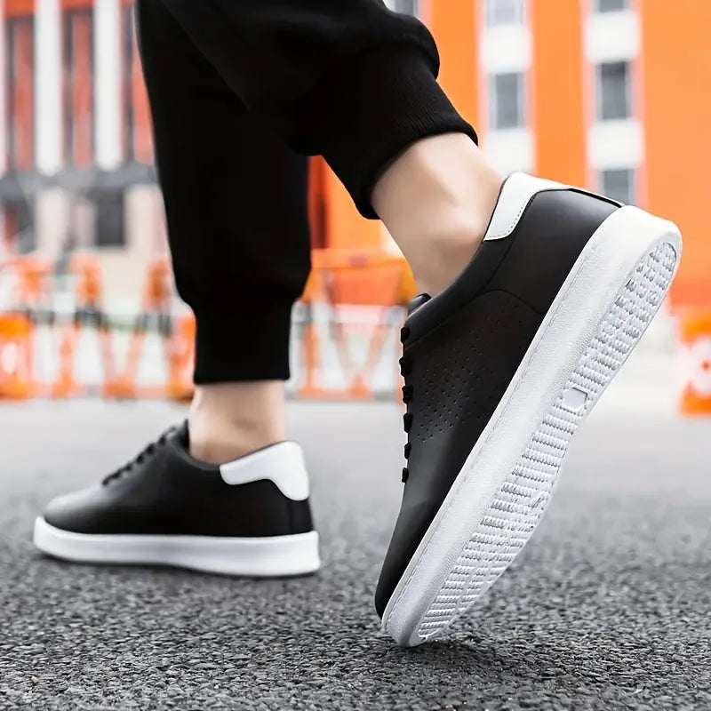 Close-up of a black trainer with white heel tab worn on foot mid-step on a city pavement