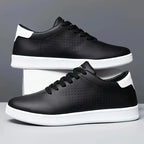 Side view of black low-top trainers with white sole and heel accent, one resting against the other