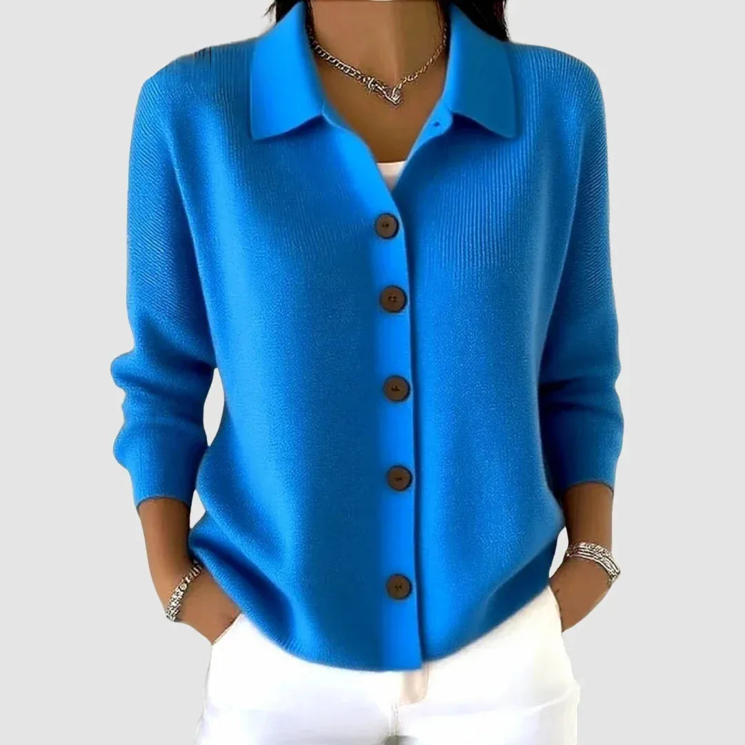 Bright blue ribbed knit cardigan with collar and wooden buttons, worn with white trousers