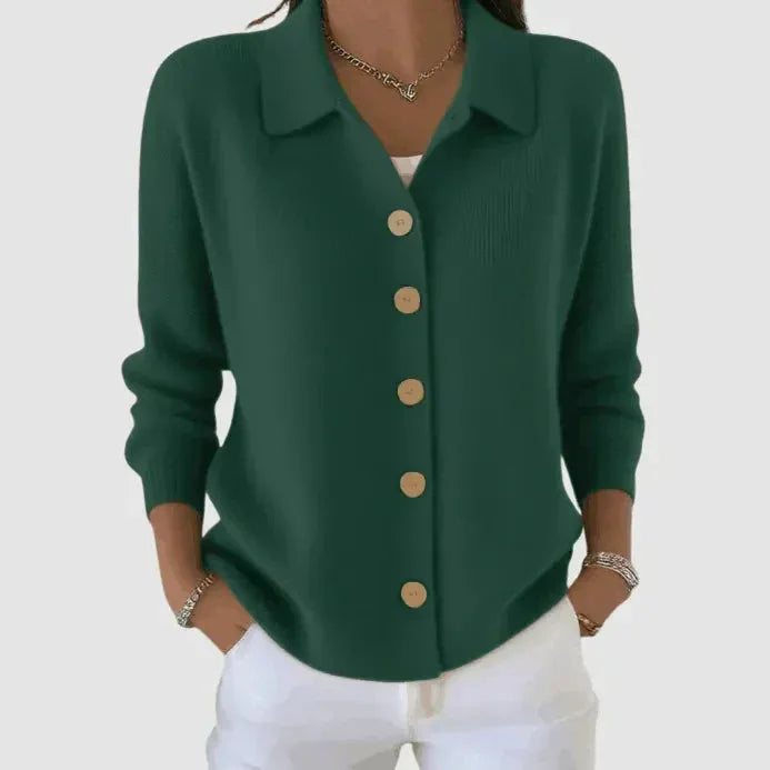 Dark forest green cardigan with collar and light wooden buttons, close-up showing ribbed knit texture