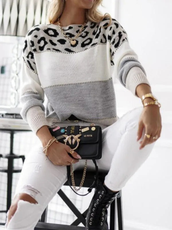 Woman wearing a colour-block leopard print knit jumper in grey and cream with a black patent chain-strap handbag