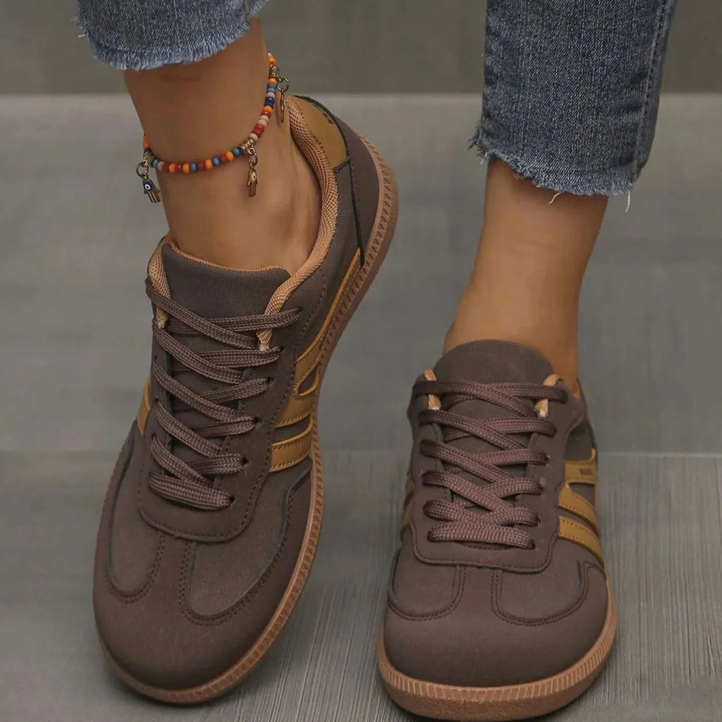 Close-up front view of brown suede trainers with tan stripes and gum outsole