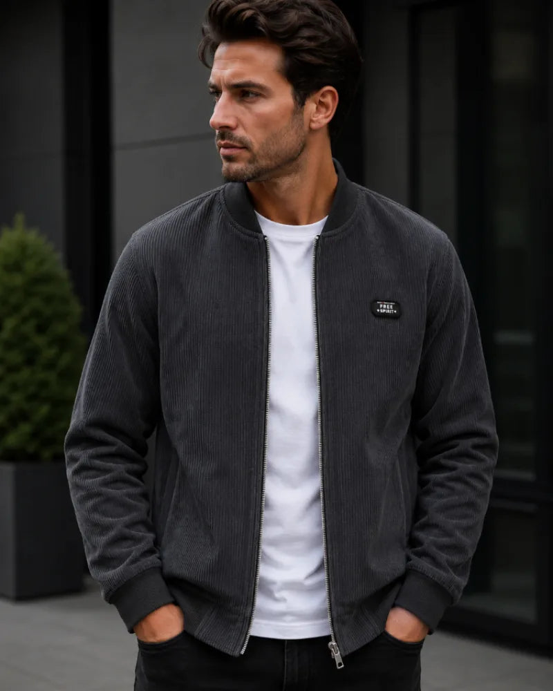 Charcoal grey corduroy bomber jacket worn open, showing ribbed hem and standing collar detail.