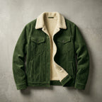 Green corduroy trucker jacket with cream sherpa collar, lying open on a concrete backdrop showing ribbed texture and snap buttons